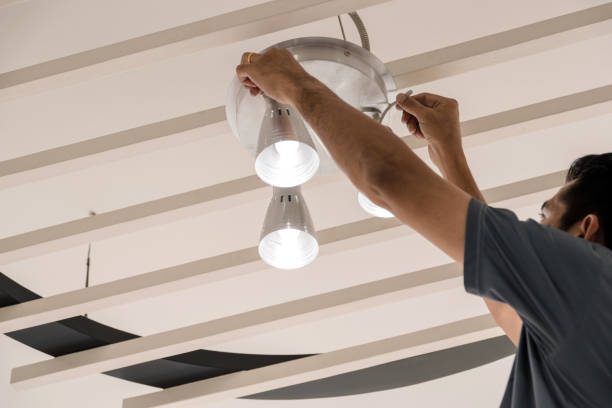 Electrical engineers are installing ceiling lamps in the hallway. Sanitaires - Bordeaux Confort Énergie - BCE